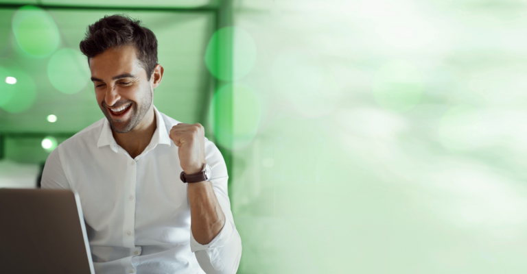 Homem feliz comemorando ao ver crescimento de indicadores financeiros em notebook